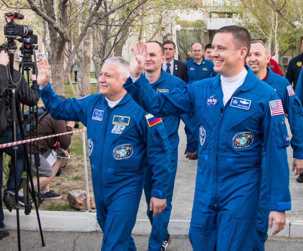 Kosmonautas Fiodoras Jurčichinas ir astronautas Jackas Fischeris mojuoja susirinkusiems žurnalistams ir žiūrovams